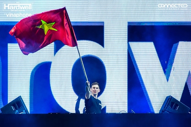Hình ảnh dj hardwell vung tay cao tương tác với đám đông khán giả cuồng nhiệt phía dưới